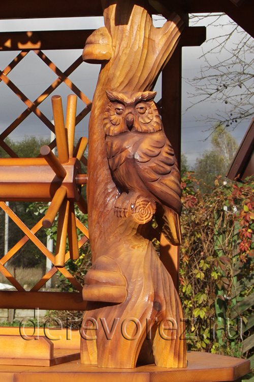 Скульптура совы украшает домик на колодец
